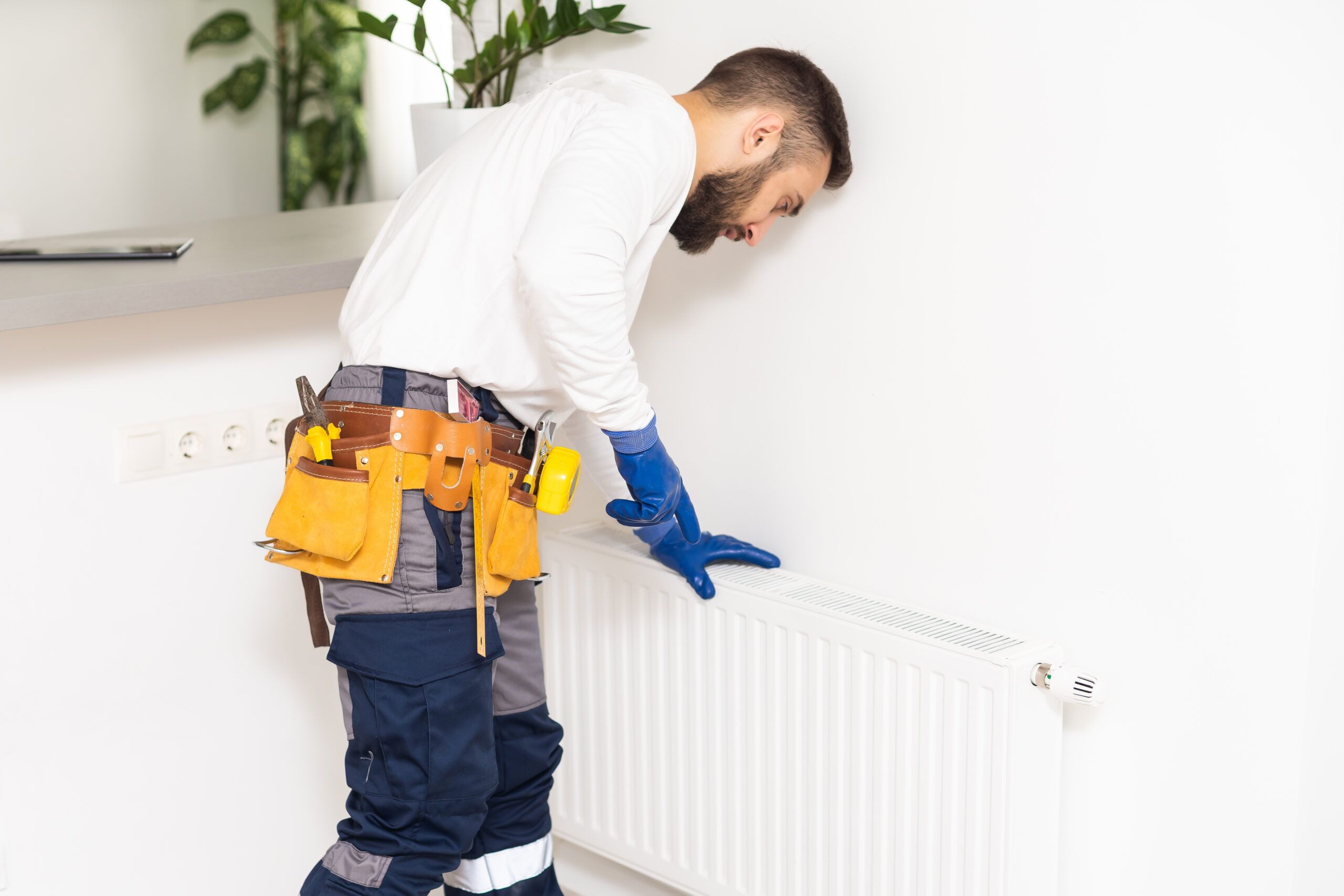 man repairing radiator with wrench. Removing air from the radiator